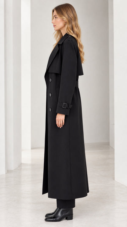 Side profile of woman wearing long black double-breasted trench coat