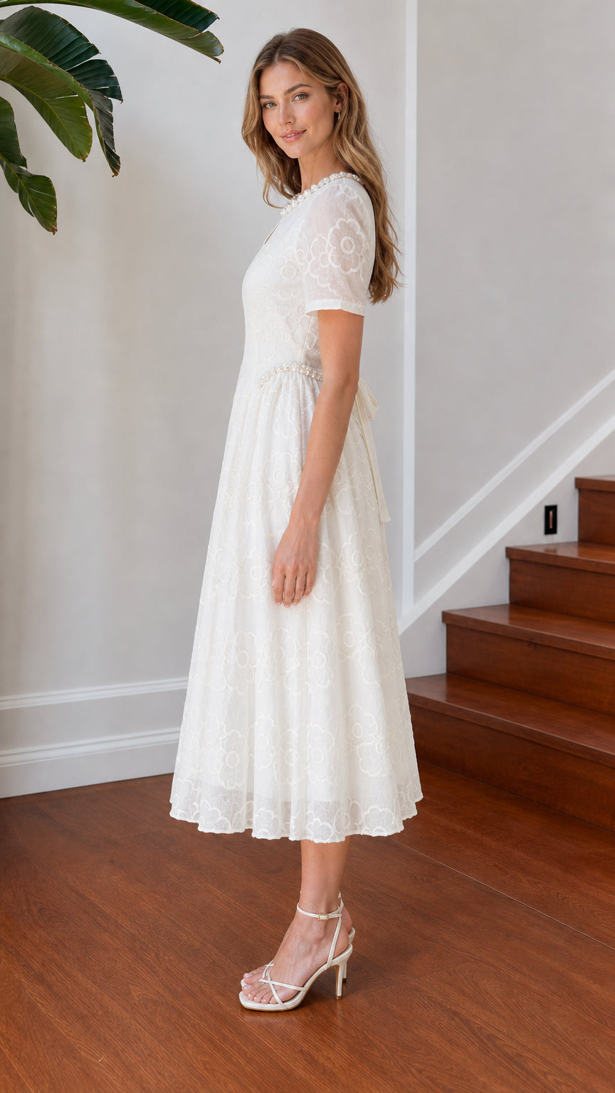 Side view of white floral lace midi dress highlighting A-line skirt drape