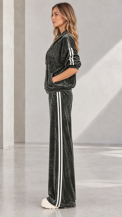 Side profile of woman in Dark Green velvet tracksuit showing sporty side stripes