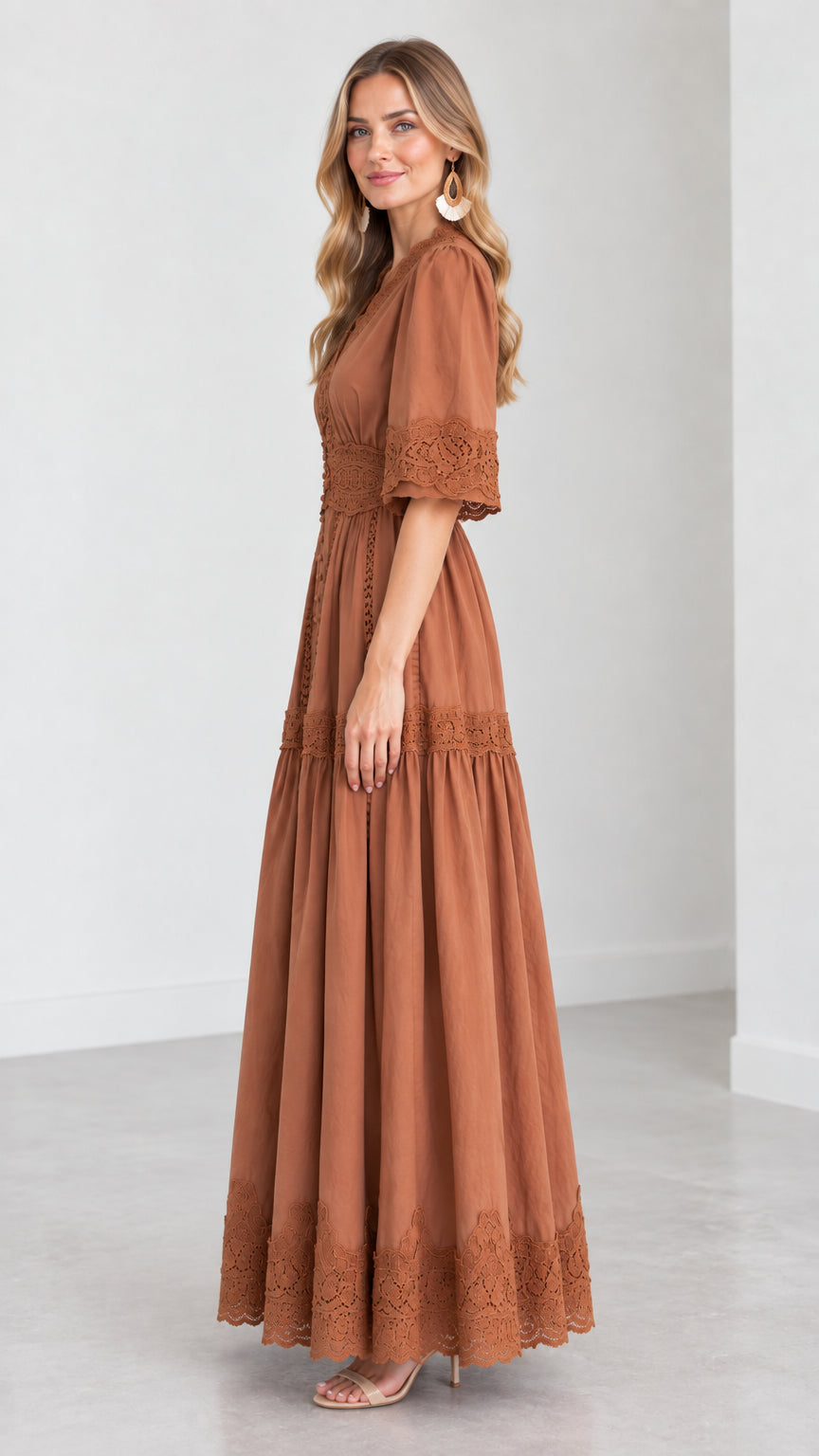 Side profile view of woman wearing a rust brown tiered maxi dress with half sleeves