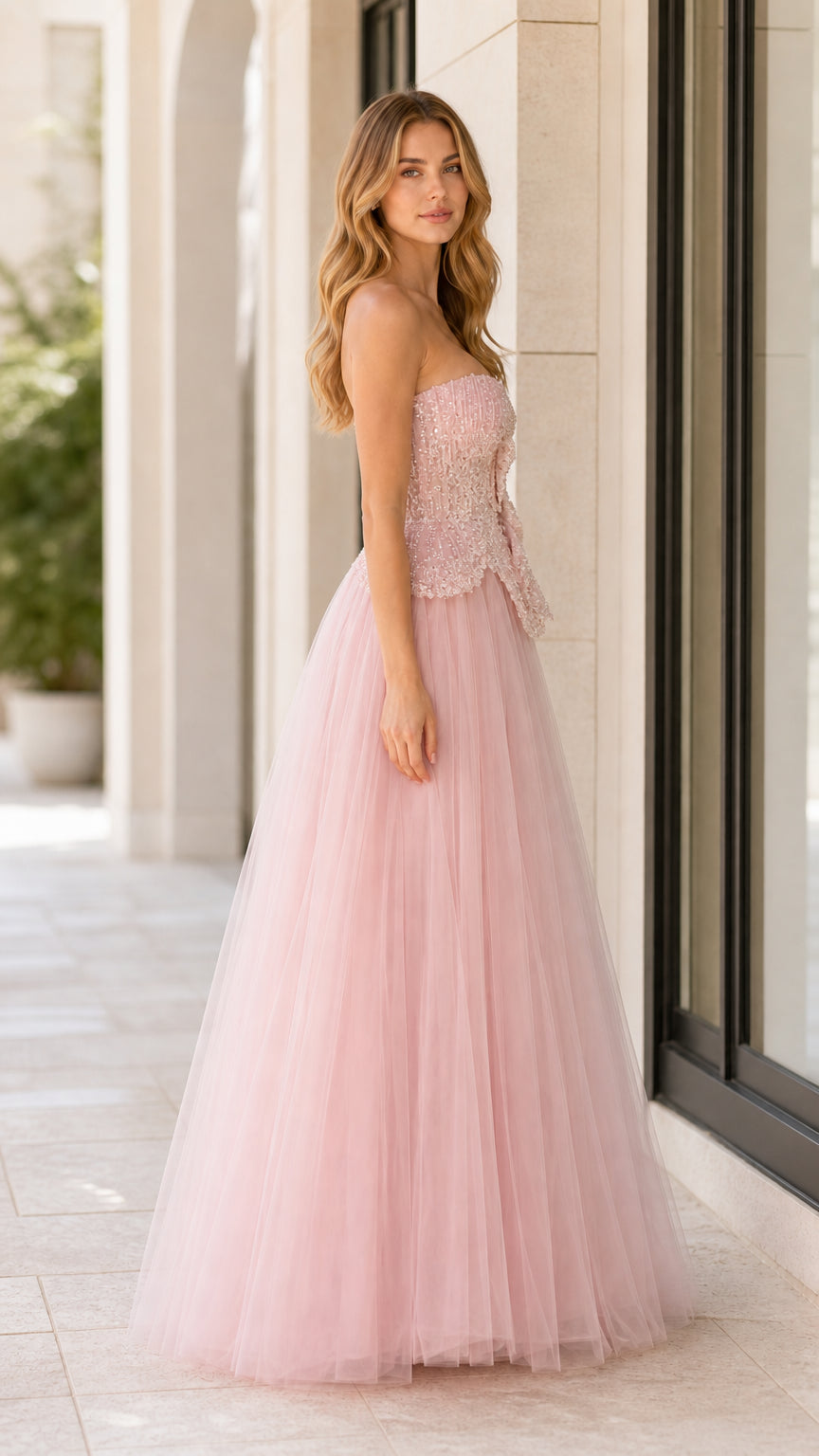 Side profile view of woman wearing blush pink strapless formal tulle dress