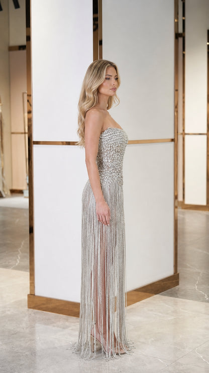 Side profile view of model in silver fringe evening gown
