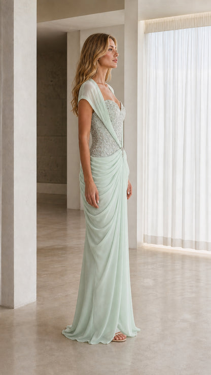 Side profile of model wearing mint green draped chiffon floor-length formal dress