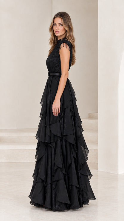 Side profile of black pleated evening dress with cascading ruffle skirt