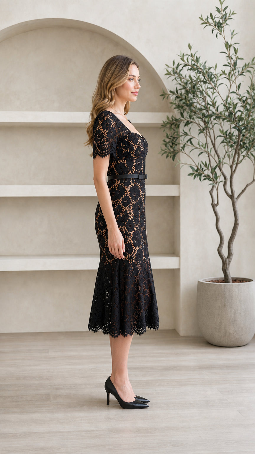 Side profile view of model wearing black floral lace mermaid midi dress