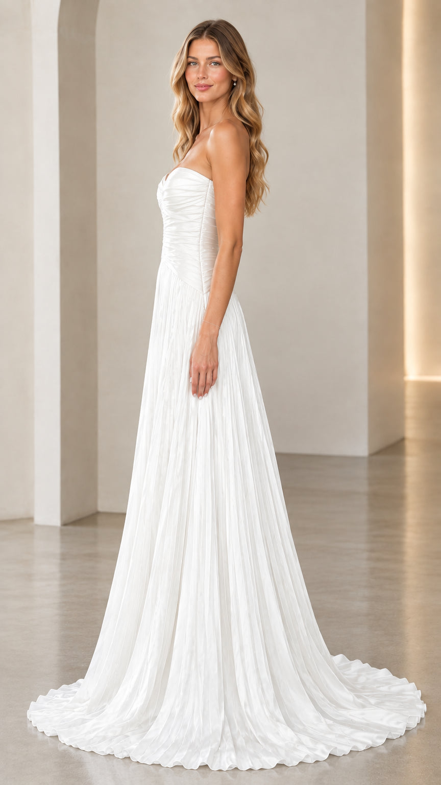 Side view of white strapless ruched maxi dress with flowing pleated skirt