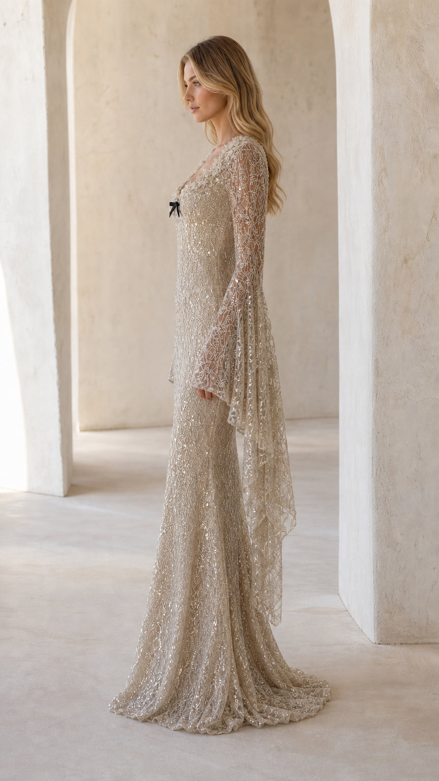 Side profile view of champagne sequin floor-length evening gown showcasing bell sleeve drape
