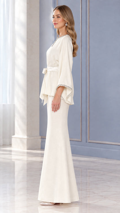 Side profile view of woman wearing Ivory two-piece embellished evening skirt set