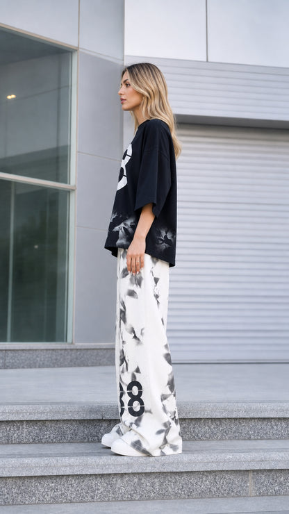 Side profile of woman wearing black graphic streetwear two-piece co-ord set