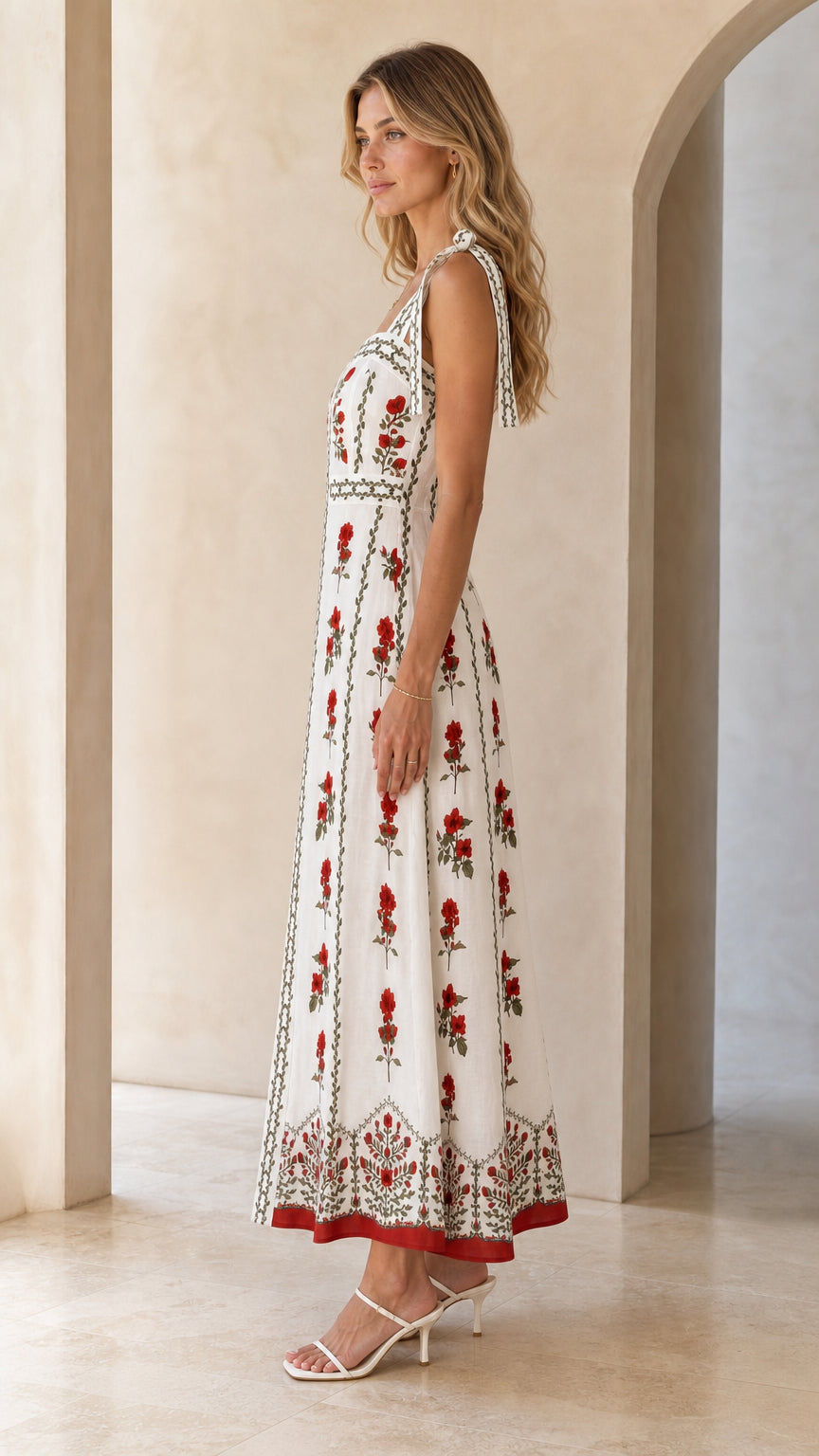 Side profile view of woman in white floral embroidered maxi dress