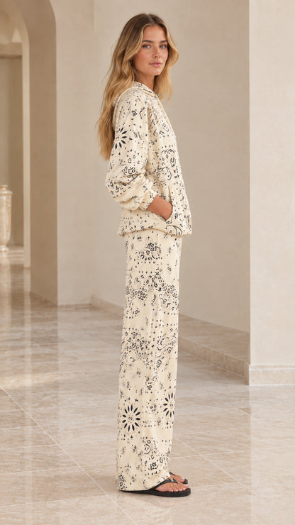 Side view of woman modeling cream paisley print two-piece lounge set