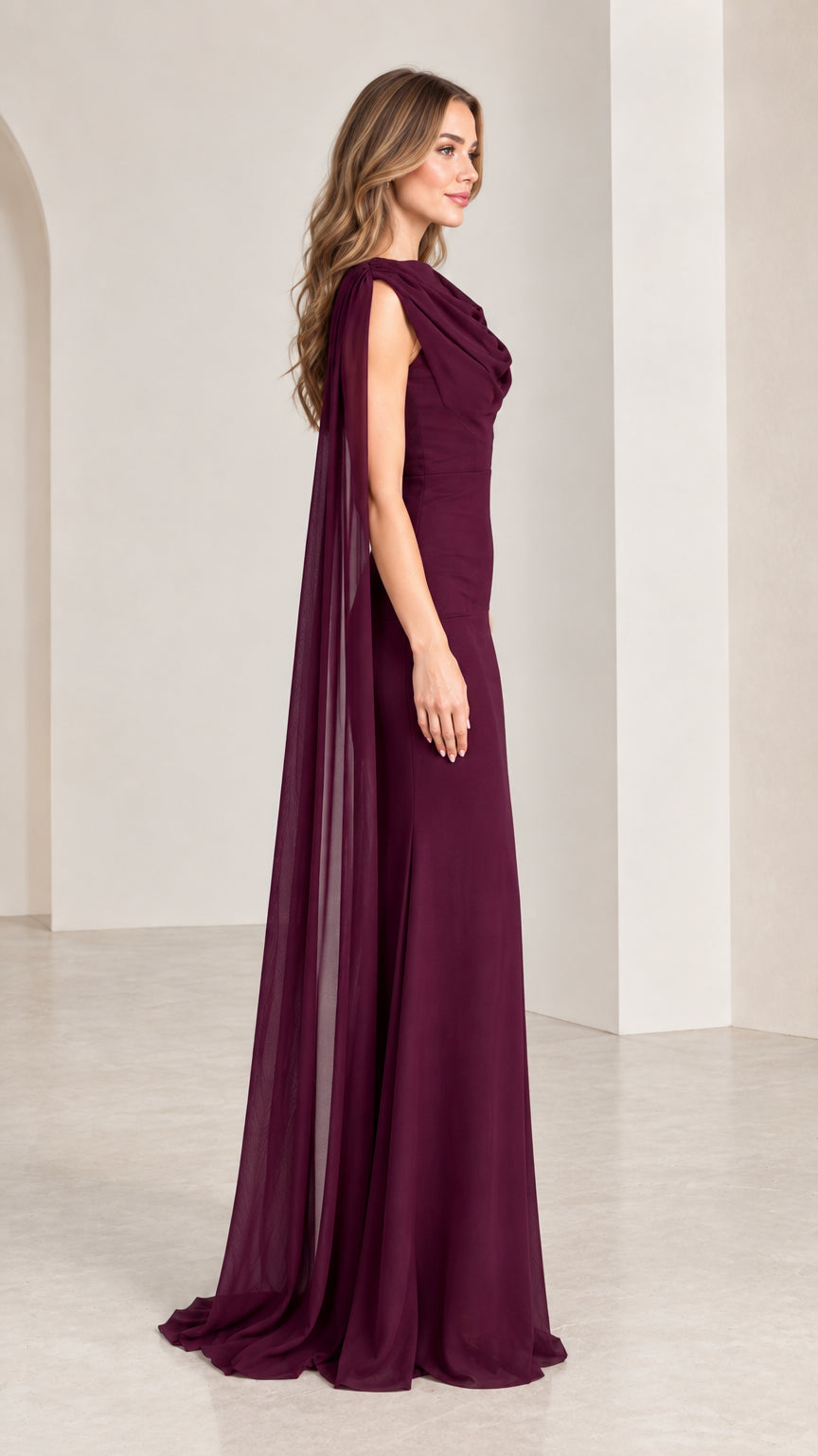 Side profile view of burgundy sleeveless formal gown with flowing cape