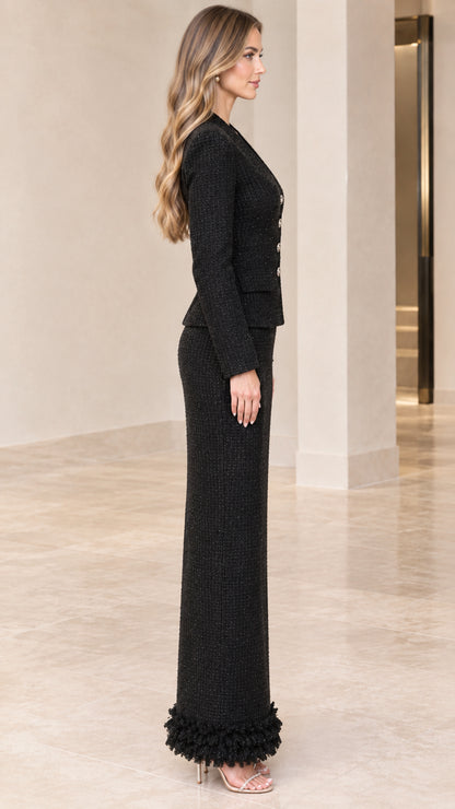 Side profile view of black tweed tailored blazer and fringe-trimmed maxi column skirt