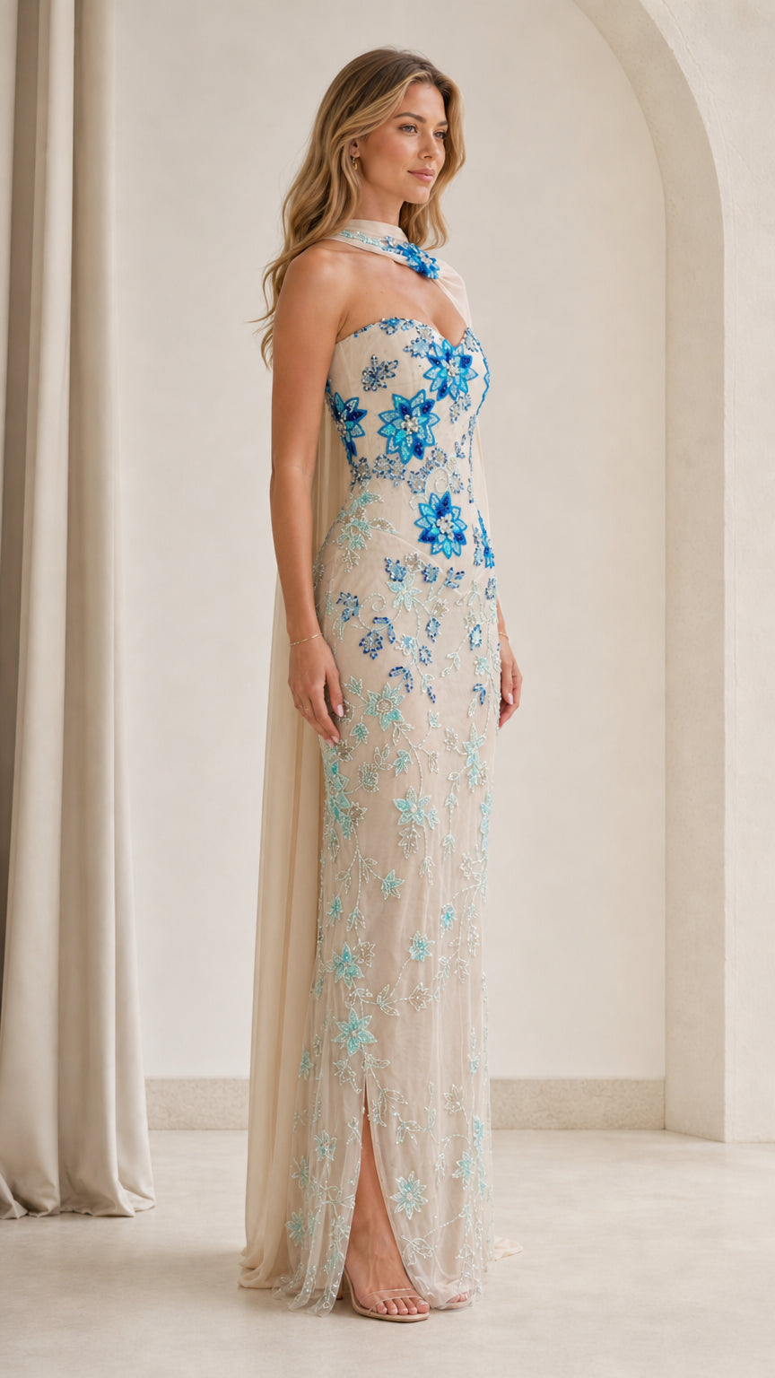 Side angle of model in champagne embellished strapless formal dress with drape