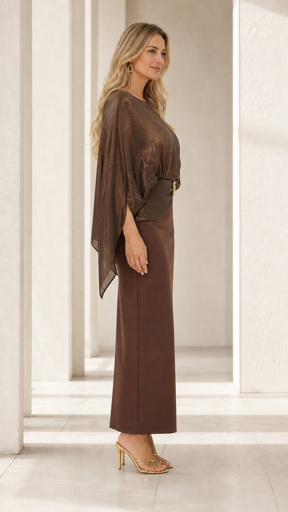 Side profile of woman wearing bronze brown cape overlay column evening gown