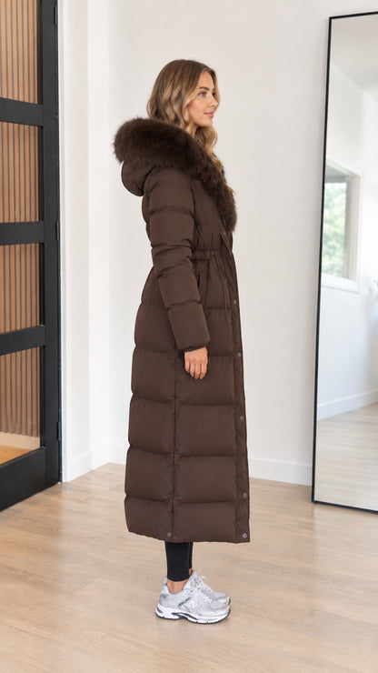 Side profile of women's long brown quilted puffer parka jacket