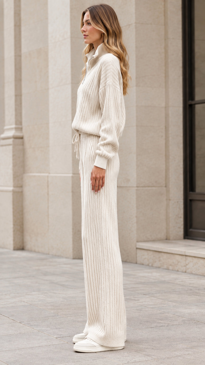 Side profile view of woman wearing cream ribbed knit two-piece sweater and pant set