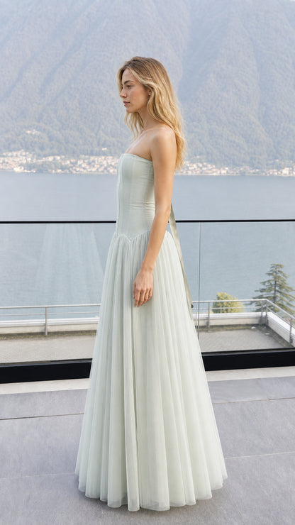 Side profile view of sage green strapless corset tulle dress outdoors