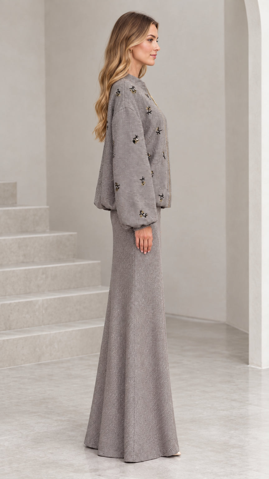 Side profile view of woman wearing grey tweed jacket and long skirt set