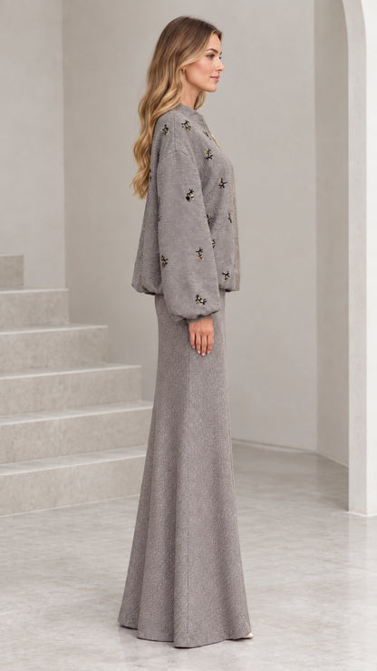 Side profile view of woman wearing grey tweed jacket and long skirt set