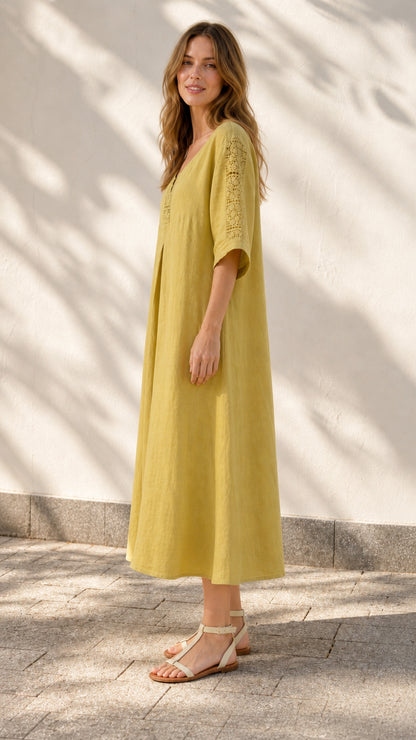 Side profile of model in yellow midi dress outdoors
