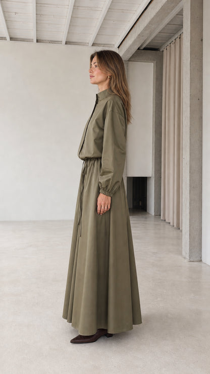 Side profile of woman wearing olive green long sleeve maxi dress