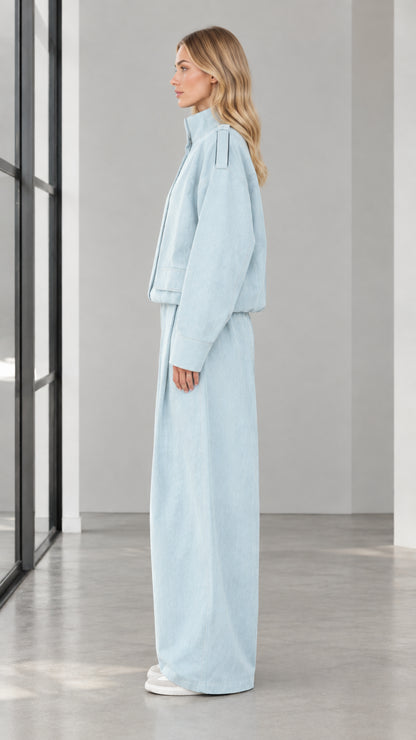 Side profile view of woman wearing Light Blue cropped jacket and matching wide leg trousers