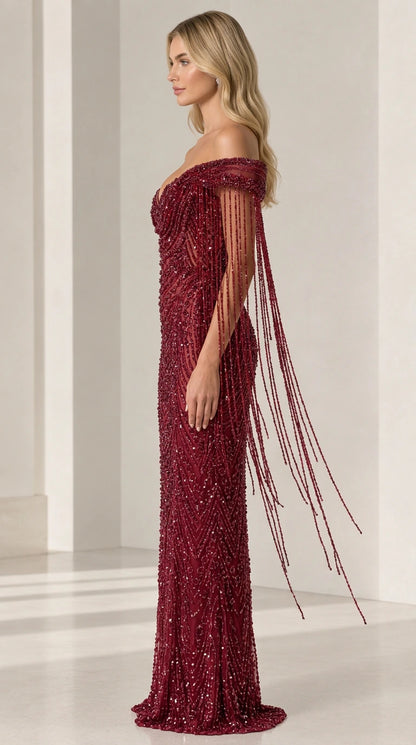 Side angle of burgundy beaded formal dress showcasing cascading fringe sleeve