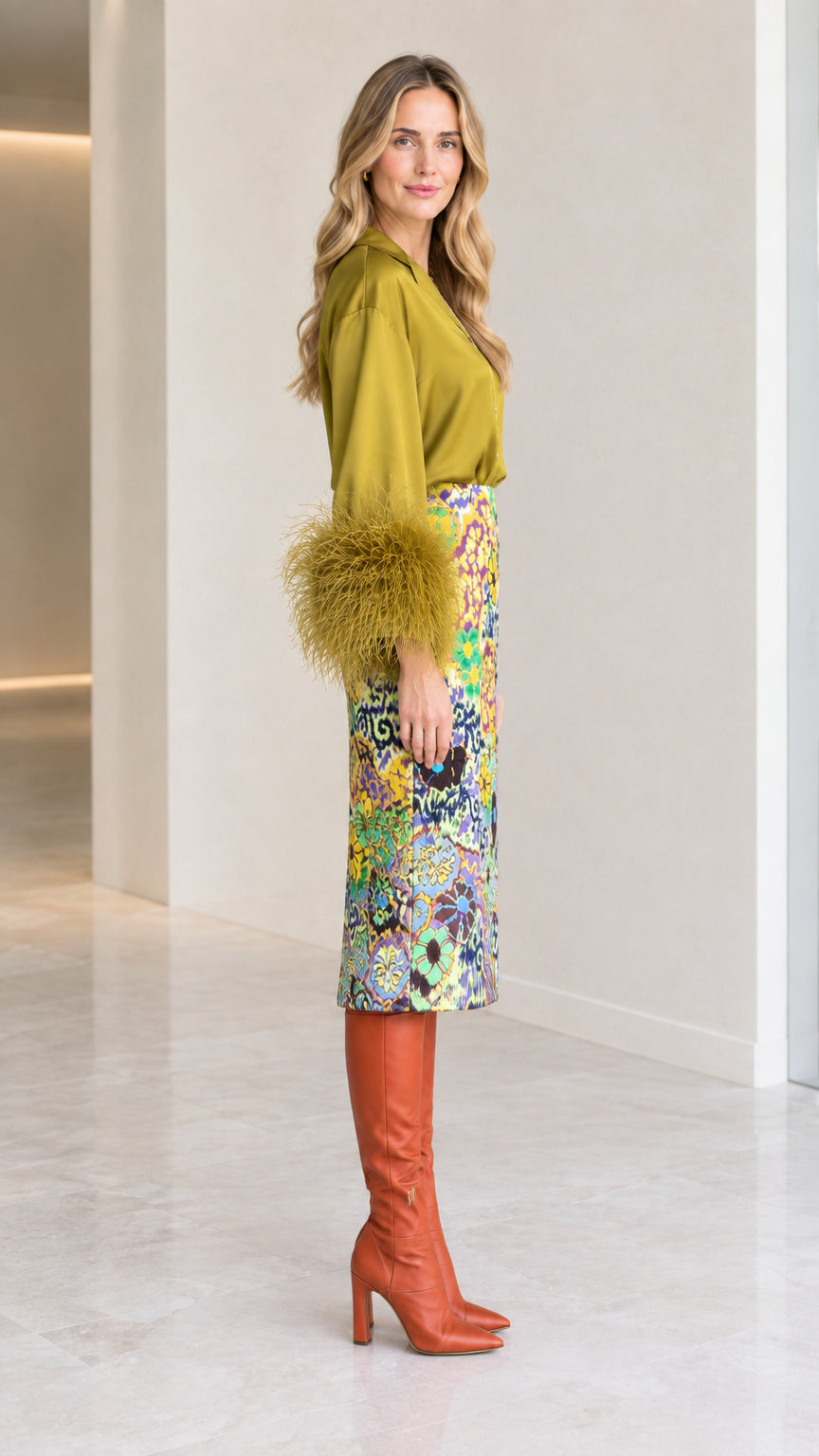 Side profile of olive green feather cuff blouse and patterned pencil skirt