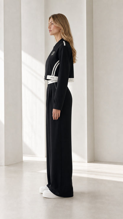 Side profile of model wearing black cropped jacket and wide-leg pants set