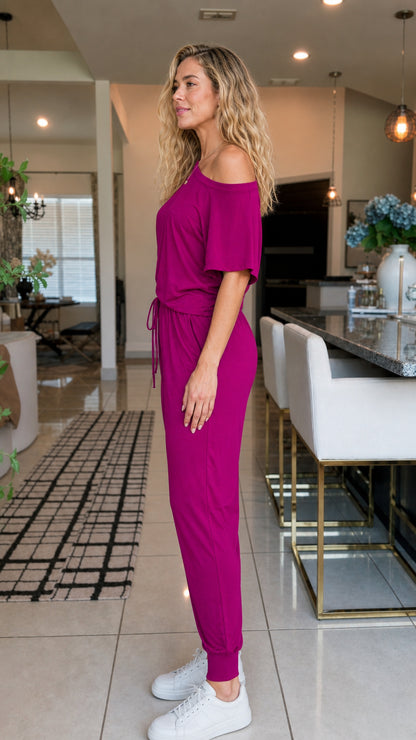 Side profile view of woman in magenta jumpsuit