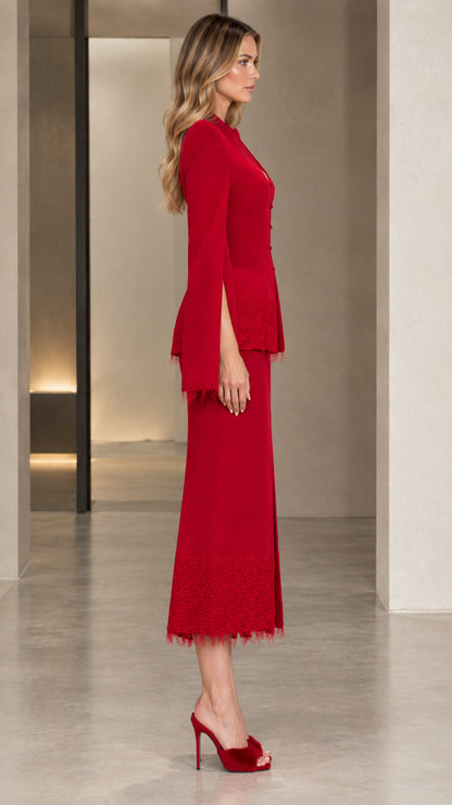 Side profile of the red tailored skirt suit showing sleeve slit and silhouette