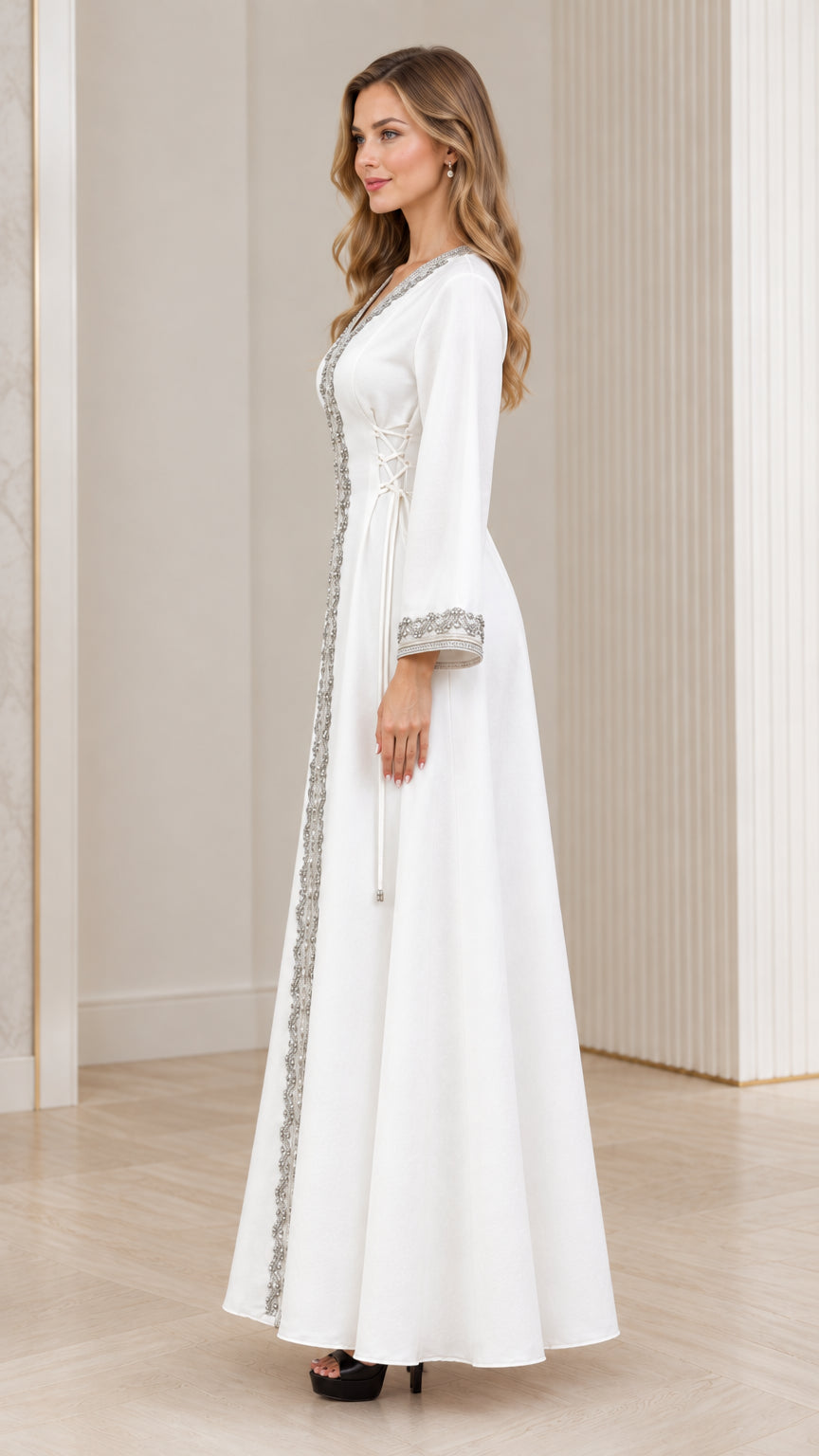 Side profile of woman wearing white embroidered full-length kaftan gown