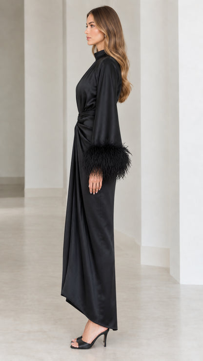 Side profile view of black satin long sleeve evening dress with feather trim