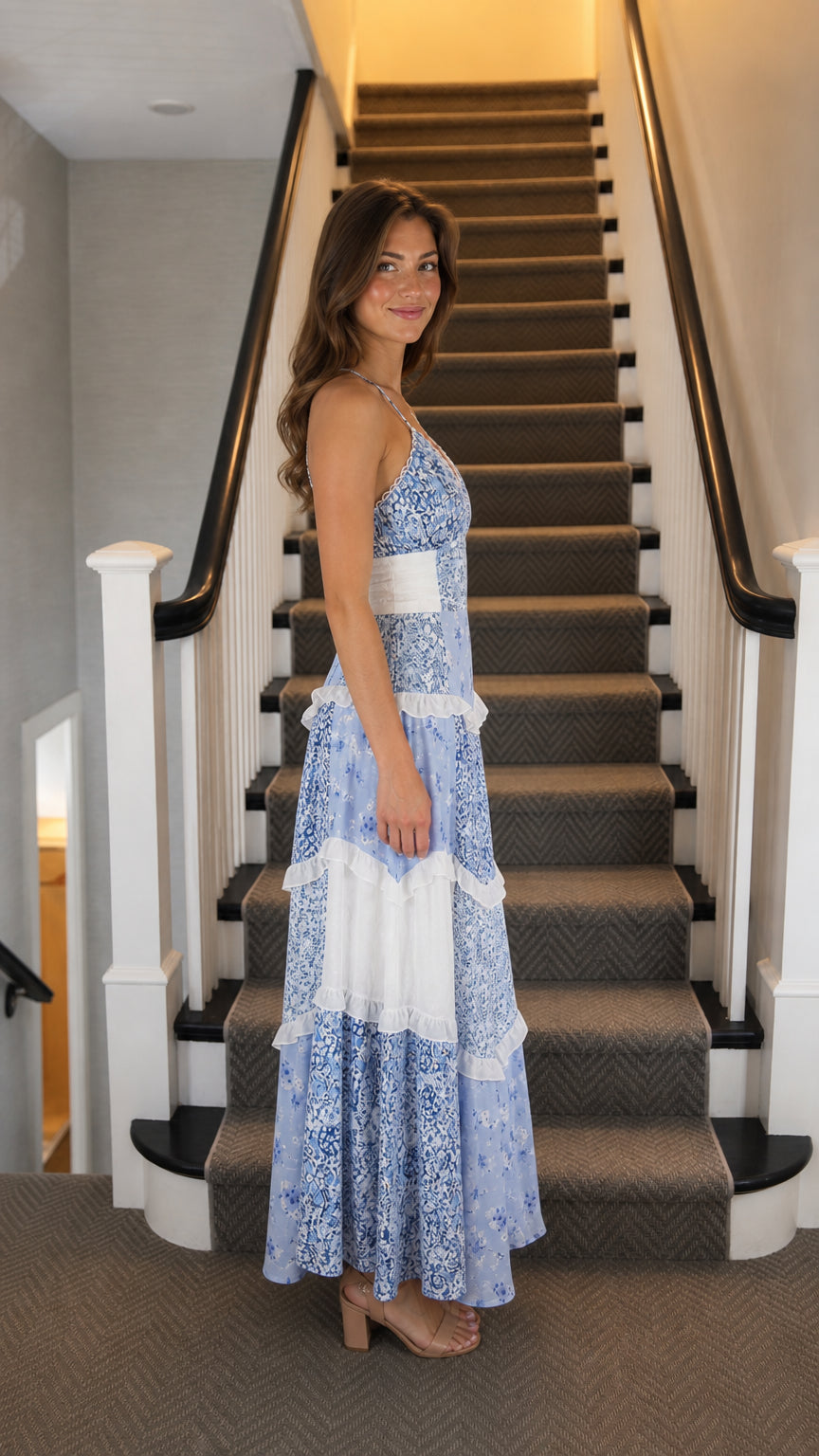 Side profile view of woman wearing blue floral tiered maxi dress