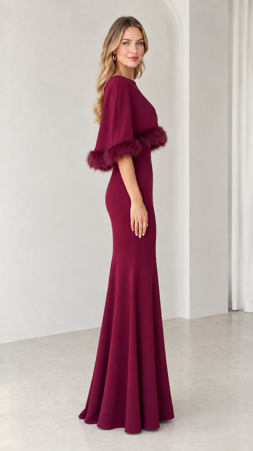 Side view of burgundy capelet maxi gown showing tailored silhouette