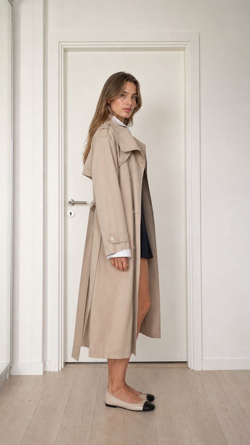 Side profile view of model wearing beige longline belted trench coat