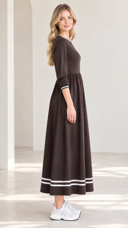 Side profile view of woman modeling brown contrast stripe trim maxi dress
