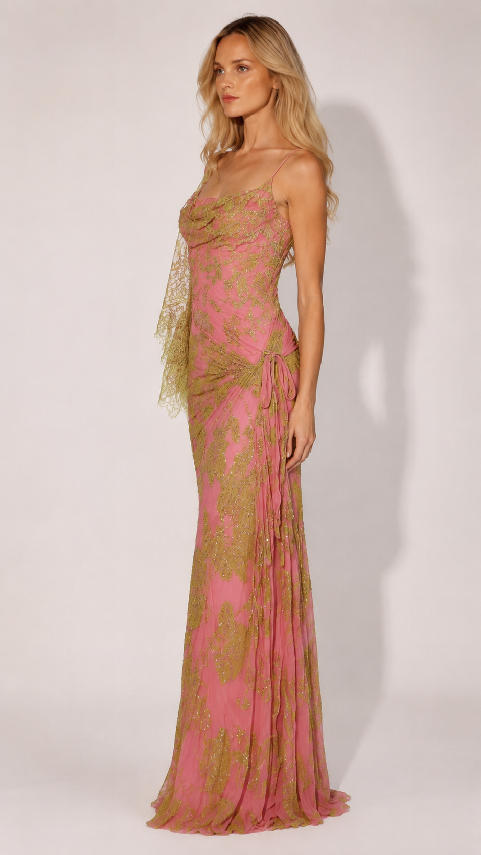 Side view of pink floor-length shimmer gown with slim straps and gathered hip detail