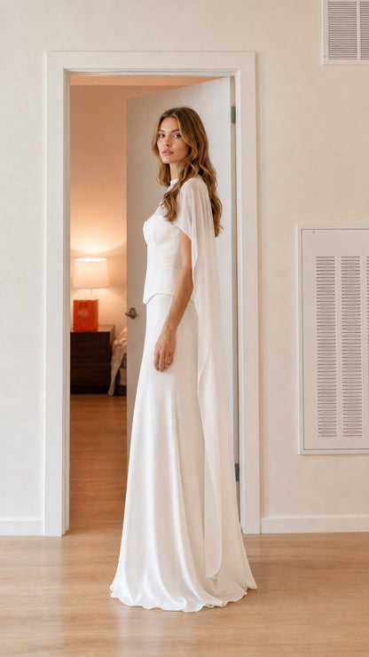 Side profile of model in white floor-length cape evening gown