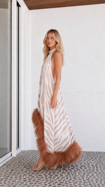 Side profile of model in beige zebra print dress