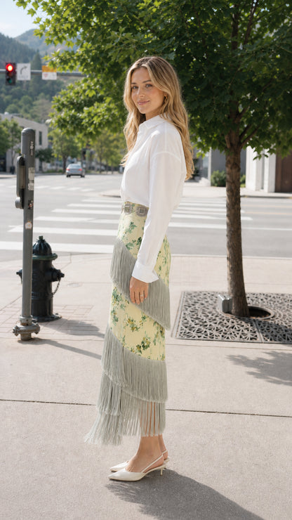 Side angle view of woman wearing pale yellow floral fringe midi skirt