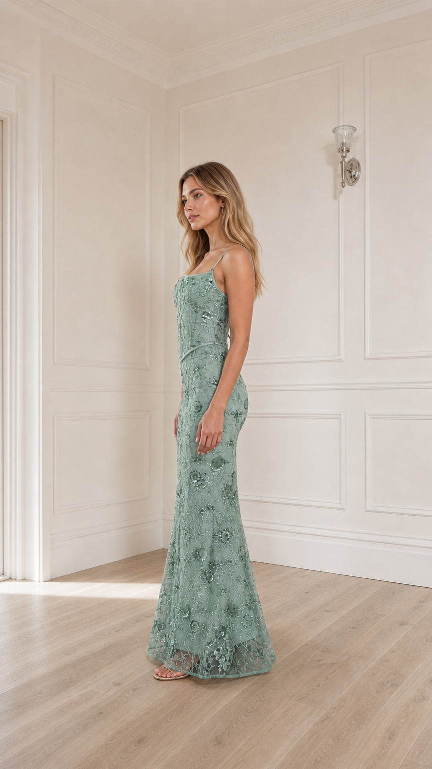 Woman wearing sage green sequin embroidered corset maxi dress, side profile