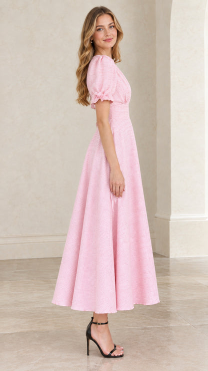 Side angle of model in pastel pink puff sleeve A-line midi dress