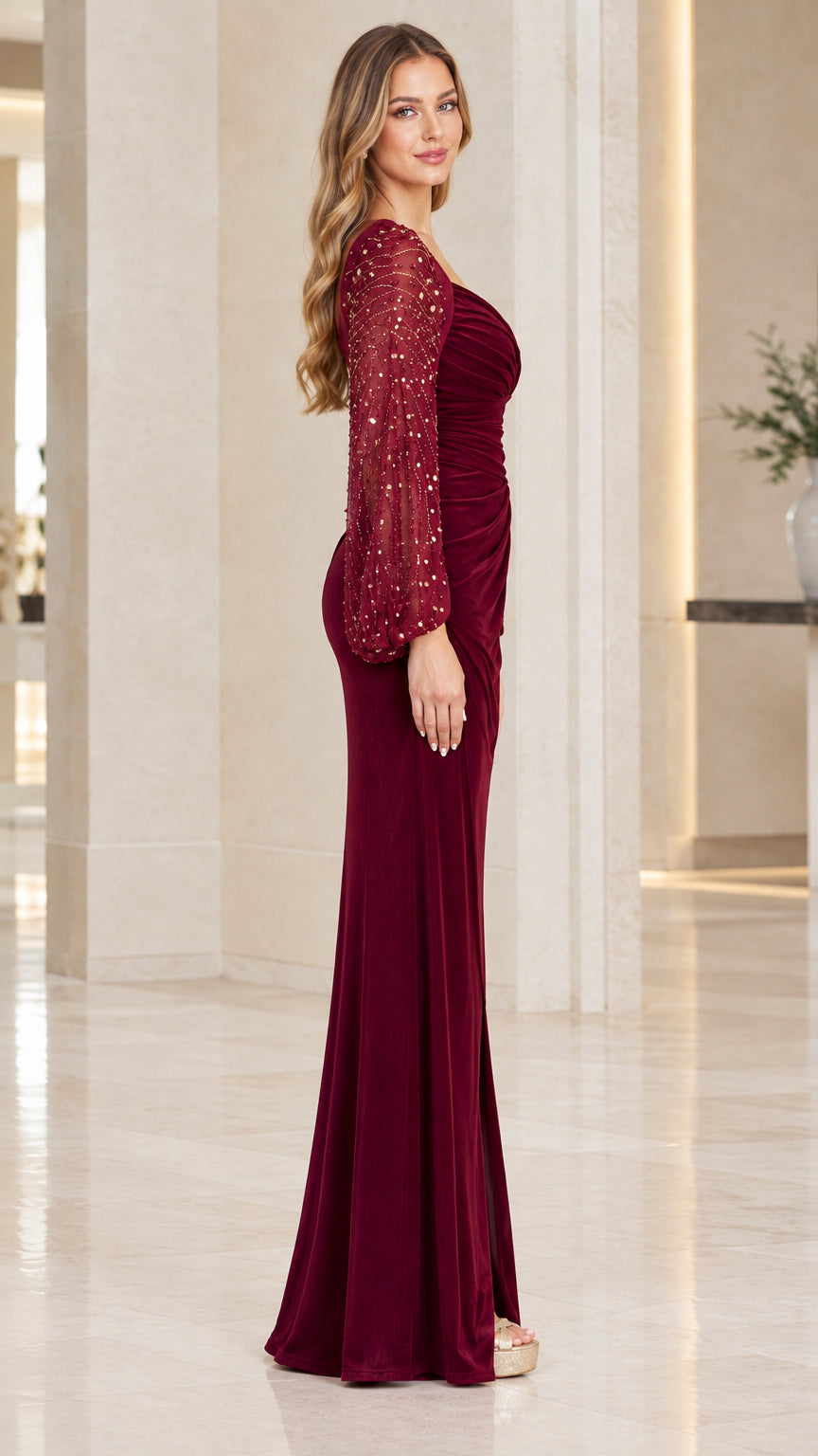 Side view of woman wearing burgundy velvet evening dress with slit