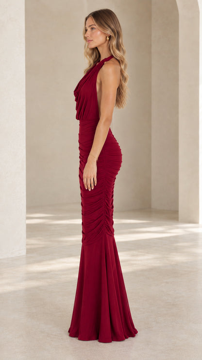 Side profile view of burgundy ruched halter floor length evening dress
