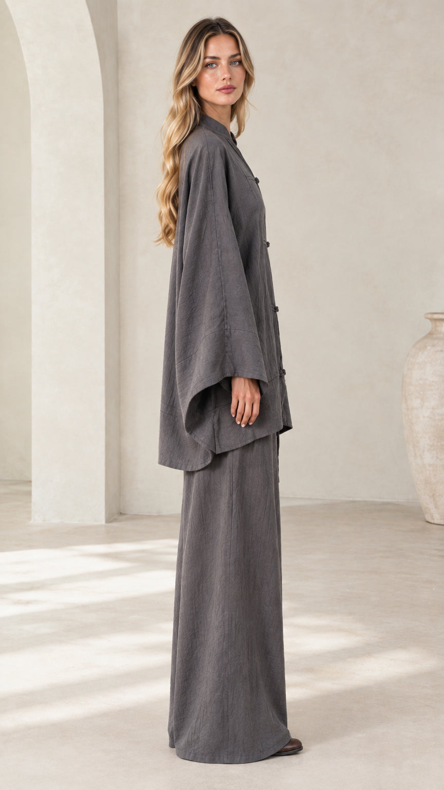 Side profile view of women's charcoal gray draped tunic top and matching palazzo pants