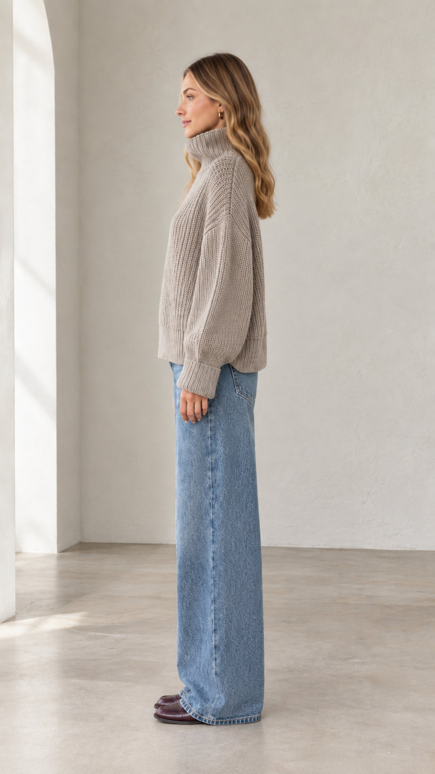 Side profile view of taupe chunky ribbed knit high neck sweater