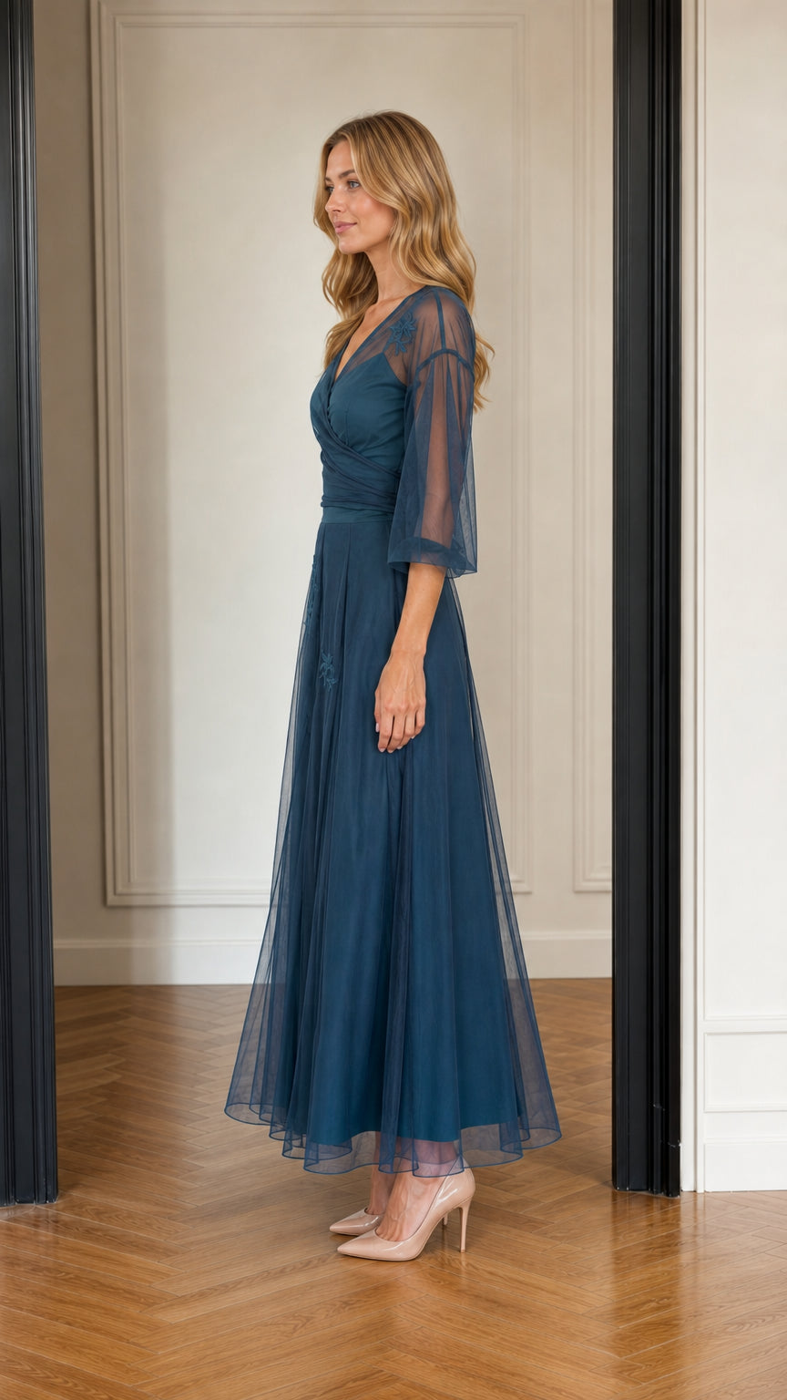 Side profile view of woman wearing teal blue tulle evening gown with 3/4 sleeves