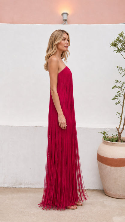 Side profile view of women's strapless tassel maxi gown in magenta